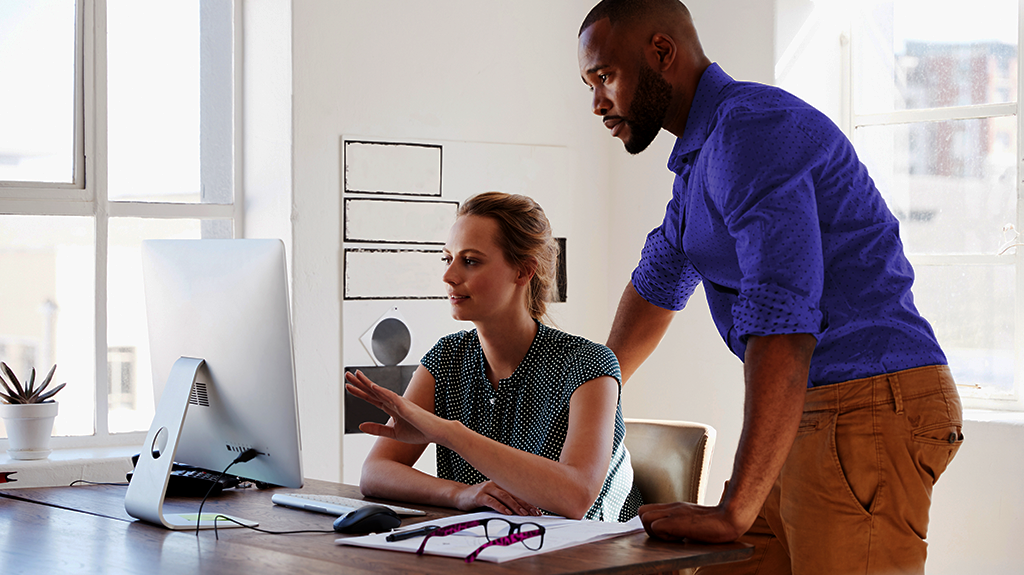 Two people checking a screen